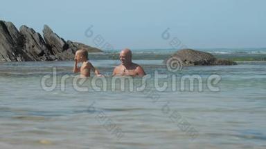 快乐的男人和小儿子一起度过蔚蓝的海湾
